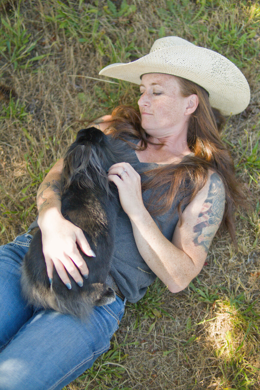Founder resting peacefully in the grass with a rabbit